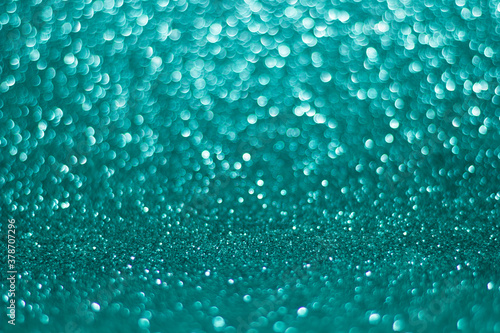 green and blue sparkle glitters with bokeh effect and selectieve focus. Festive background with bright gold lights, champagne bubble. Christmas mood concept. Copy space, close up, texture, top view.