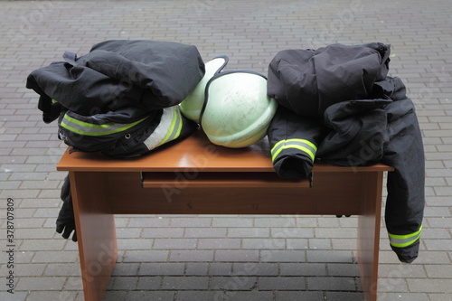 Rescuer firefighter protective rescue equipment wear close up on table outdoor - fire guard helmet, special fireproof clothing, gloves photo