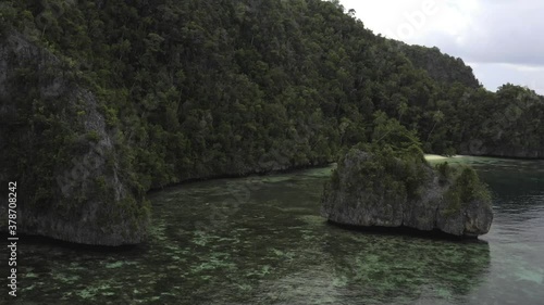 Raja Ampat, Misool, slow aerial pan of secluded beach next to steep jagged cliffs