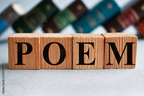 poem writing on wooden cubes and books on the background photo