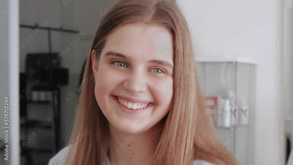 Young happy female model looks at the camera and smiles Young happy female model looks at the camera and smiles