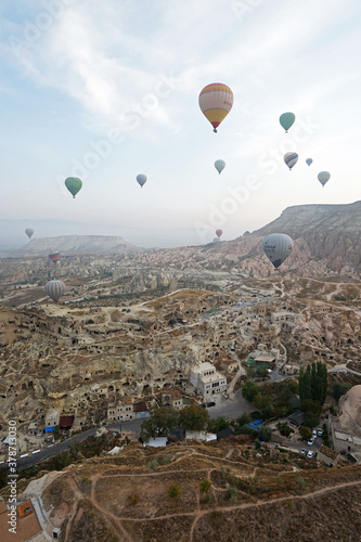 Colorful hot air balloon ride and tour in Goreme valley, semi-arid region in central Turkey known for its distinctive fairy chimneys, tall, cone-shaped rock formation- Cappadocia, Turkey