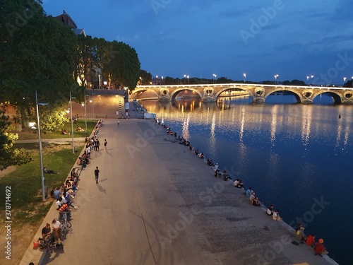 In Toulouse, South of France, young people on the banks of the river and enjoying the heat of the late summer in a beautiful environment.