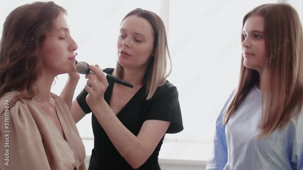 Adult professional teacher visagiste training her young student to become makeup artist at master class in beauty salon. Adult professional teacher visagiste training her young student to become makeup artist at master class in beauty salon.