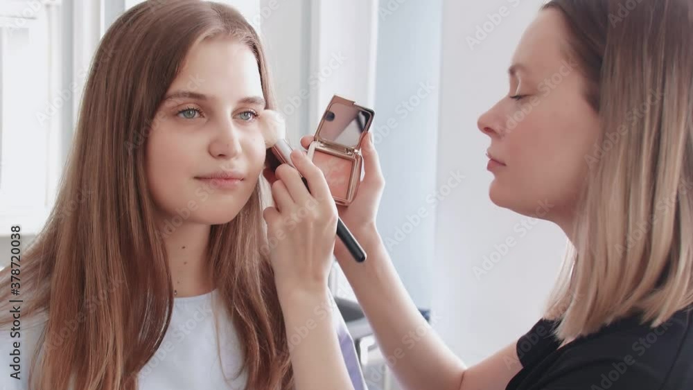 Professional make up artist uses big brush to apllies tone or powder Professional make up artist uses big brush to apllies tone or powder