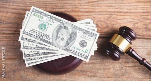 Judge gavel and money on brown wooden table.