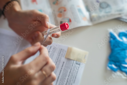 Process of coronavirus testing examination at home, COVID-19 swab collection kit, test tube for taking OP NP patient specimen sample, testing carried out, patient receiving a corona test