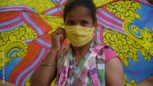 Young Indian woman girl from Mumbai puts on a face mask and takes it off with a natural beautiful smile during pandemic photo