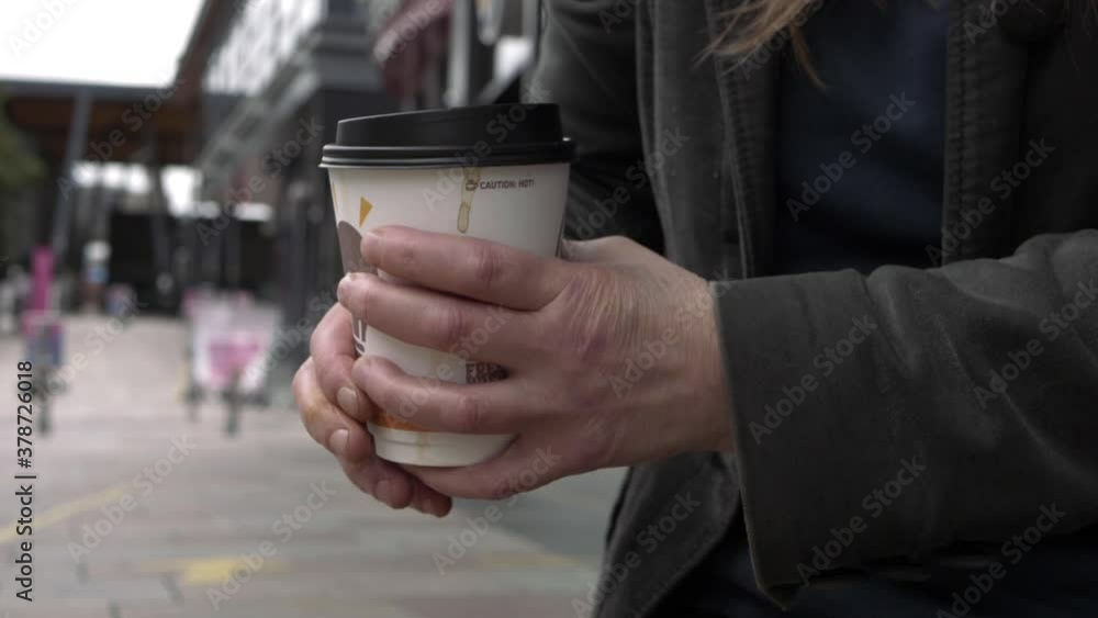 Hands holding coffee take out cup in city medium shot Hands holding coffee take out cup in city medium shot