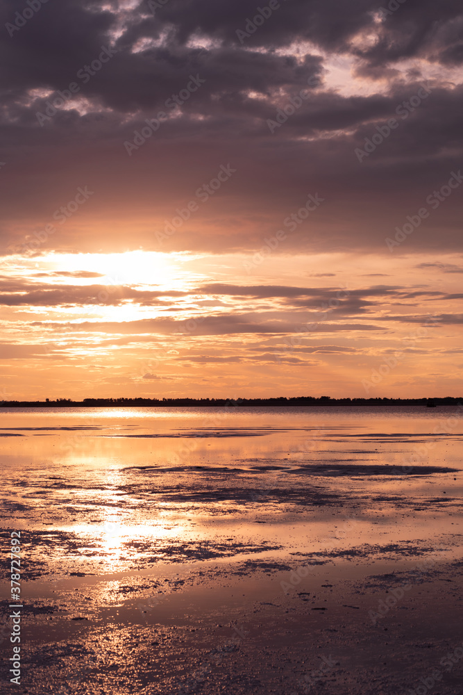 Golden sunset with colorful sky and water in lake reflected in evening