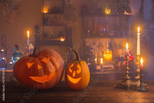Halloween pumpkins with candles and magic potions at night indoor