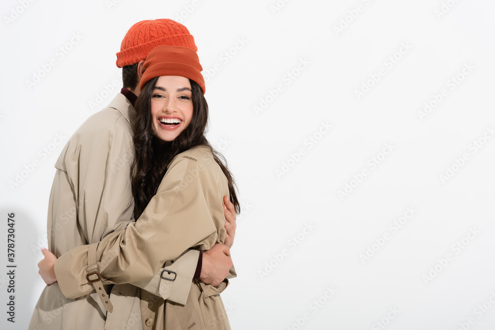 trendy woman in beanie hat hugging man on white trendy woman in beanie hat hugging man on white