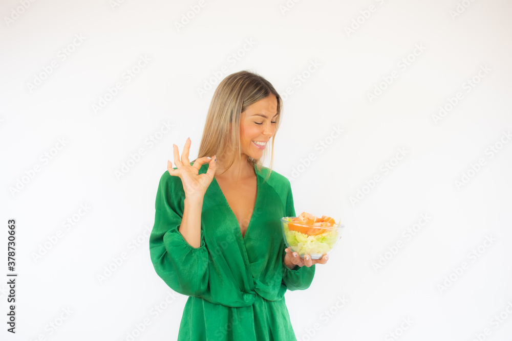 Woman making okay gesture while holding a salad Woman making okay gesture while holding a salad