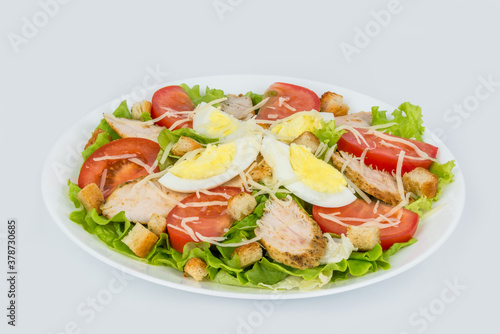 Caesar salad with fresh herbs in a white plate