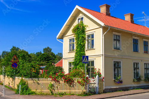 Residential house on a street corner with blooming roses