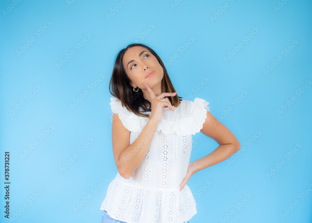 Woman in white clothes with a doubtful expression Woman in white clothes with a doubtful expression