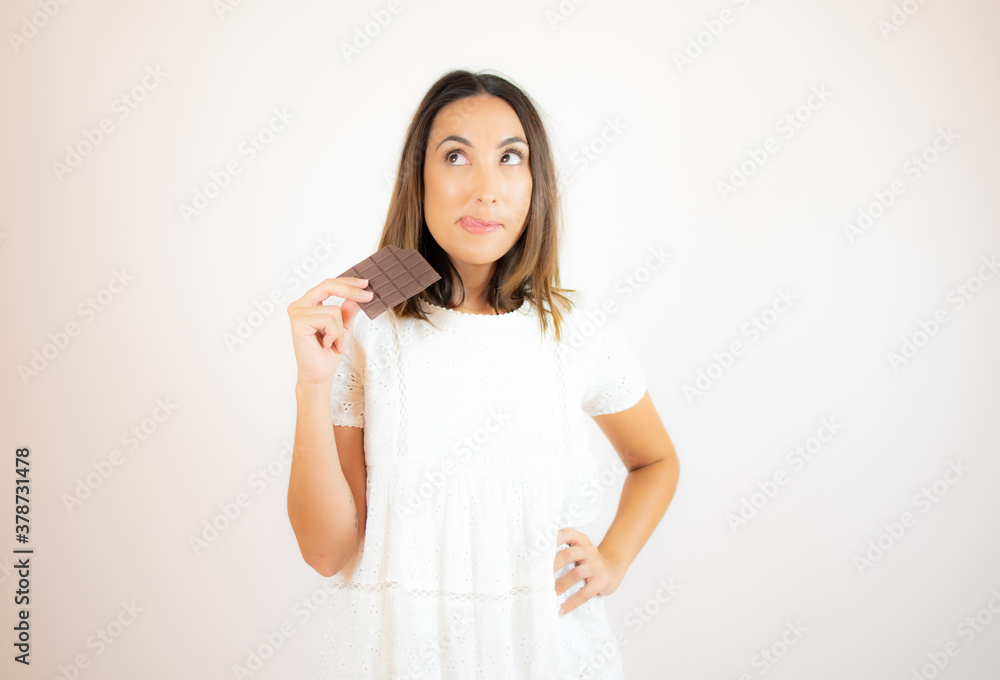 Woman holding a chocolate bar with an expression of desire Woman holding a chocolate bar with an expression of desire