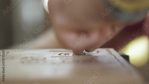 close-up. carpenter carves letters with woodcarving with a chisel. Woodworking and craftmanship concept.