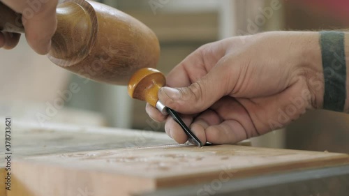 close-up. carpenter makes wood carving with a chisel and mallet. Carpentry, craftsmanship, design, manufacturing concept.