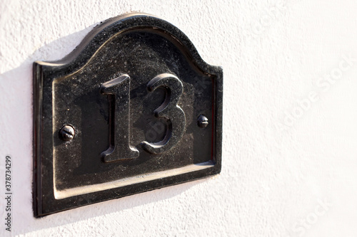House number 13 on concrete wall. Copy space is on the right side. 