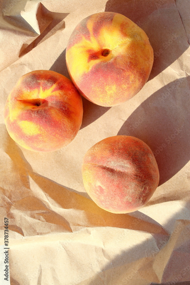 Three juicy, ripe and sweet peaches on wrapping paper. Seasonal summer fruits. Three juicy, ripe and sweet peaches on wrapping paper. Seasonal summer fruits.