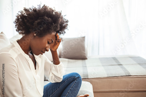 Young hopeless woman suffering from depression having nervous breakdown holding head on isolated background, copy space. Woman suffering from stress or a headache grimacing in pain