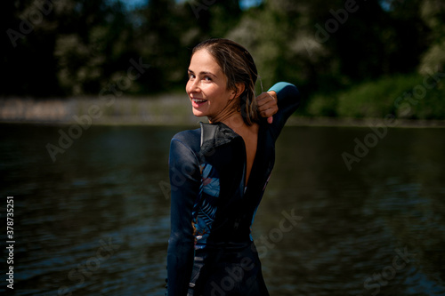 Obraz na plátně rear view of woman in wetsuit with open zipper and her head turned