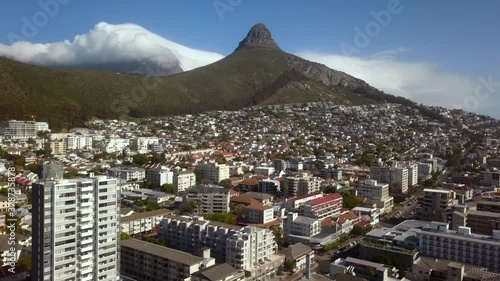 Flying over Skyscrapers with Spectacular Lions Head Mountain in Background, surrounded by Incredible Clouds, South Africa, Drone