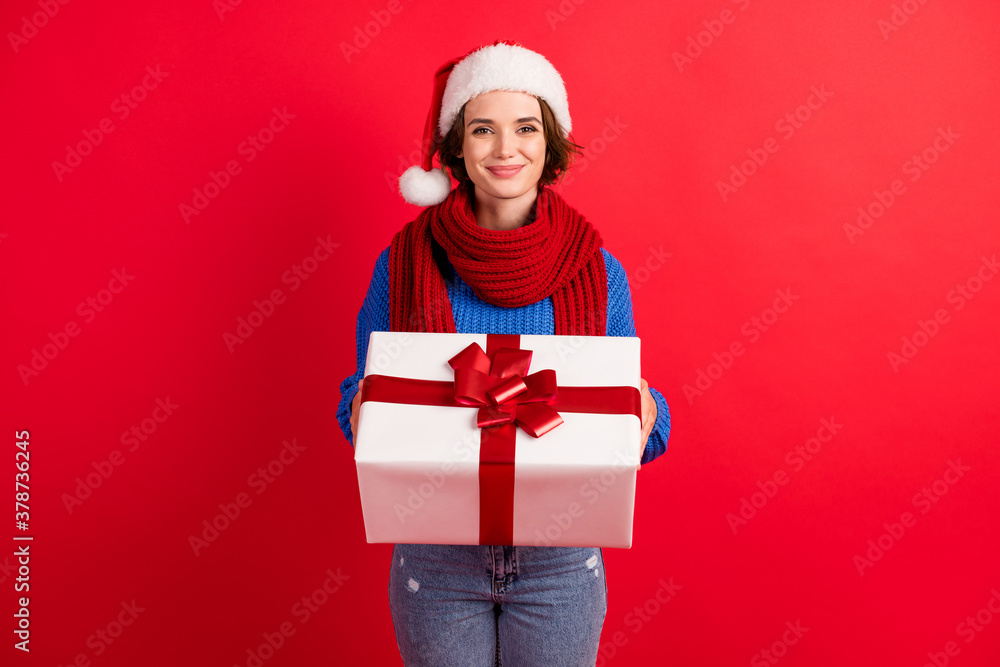 Photo of positive girl in santa claus headwear get receive christmas jolly greeting big gift box wear blue knitted sweater denim jeans isolated over bright shine color background Photo of positive girl in santa claus headwear get receive christmas jolly greeting big gift box wear blue knitted sweater denim jeans isolated over bright shine color background