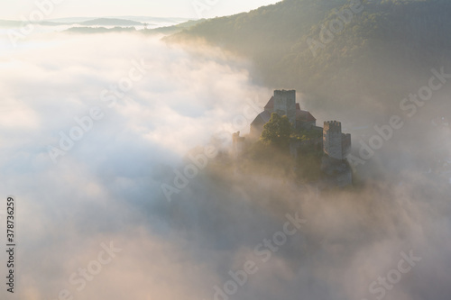 Hardegg medieval castle on a fortified hill upon Thaya river during summer or autumn time. Misty big ruins in the Thayatal Valley  National park  Lower Austria. The Smallest Austrian town.