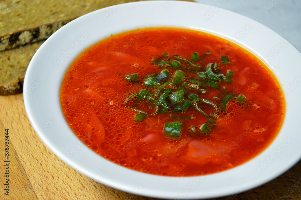 Borscht and two pieces of rye bread on a wooden background. Borscht and two pieces of rye bread on a wooden background.