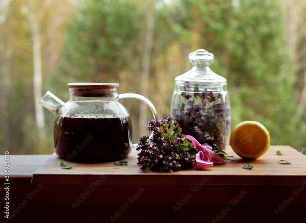 a bouquet of herbs and tea stands on a wooden veranda a bouquet of herbs and tea stands on a wooden veranda