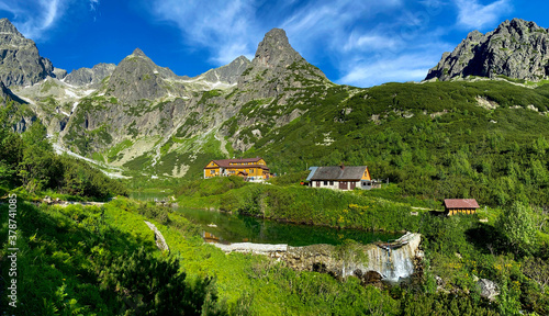 Slovakia landscape. Hut near the Zelene pleso, Vysoke Tatry NP, Europe. Sunny say in the mountains. Rocky hill isn summer season. High Tatras, lake with green forest. Travel in Slovakia. photo