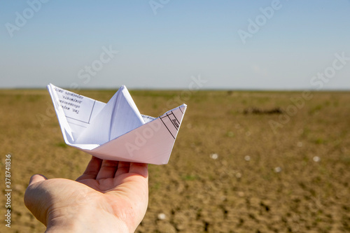hand holding a paper boat