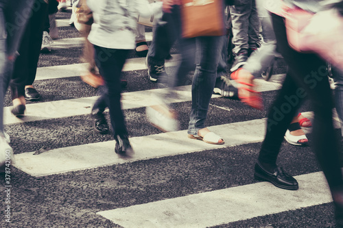 Blurred people crossing the street on a zebra crossing. Toned © gesrey