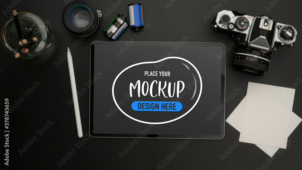 Mock up digital tablet on black table with camera, notepad, lens and stationery Mock up digital tablet on black table with camera, notepad, lens and stationery