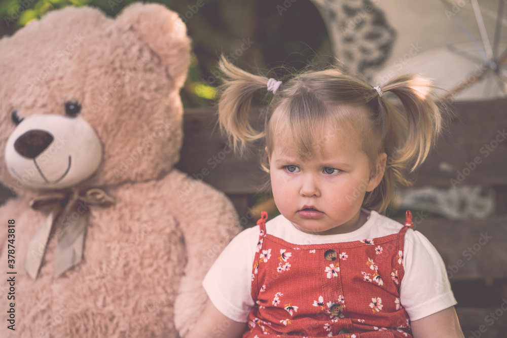 Süßes Kleinkind Mädchen mit rotem Kleid und Zöpfen großer Teddybär Sonnenschirm böse schauend outdoor hölzener Hintergrund vintage Var. 9 Süßes Kleinkind Mädchen mit rotem Kleid und Zöpfen großer Teddybär Sonnenschirm böse schauend outdoor hölzener Hintergrund vintage Var. 9