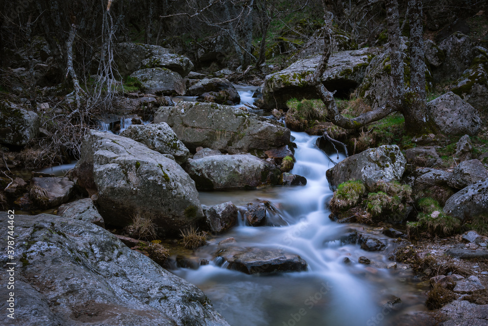 River water flows among the rocks and forms small waterfalls, Rascafría, Madrid, Spain River water flows among the rocks and forms small waterfalls, Rascafría, Madrid, Spain