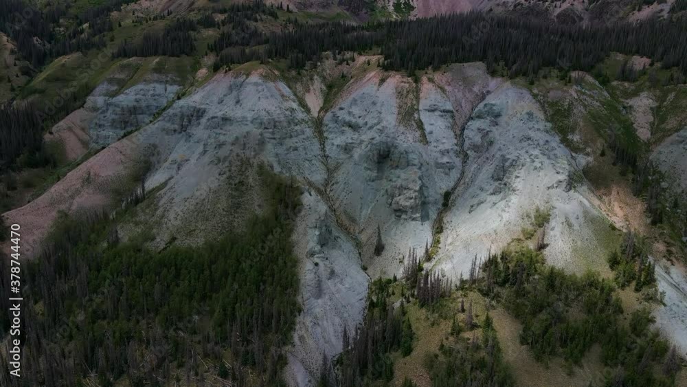 Aerial view Ascending shot, Scenic view of landslide on Hills of San Juan Mountain Range in Colorado, Clouds Shading Mountain and Pine Trees in the background. Aerial view Ascending shot, Scenic view of landslide on Hills of San Juan Mountain Range in Colorado, Clouds Shading Mountain and Pine Trees in the background.