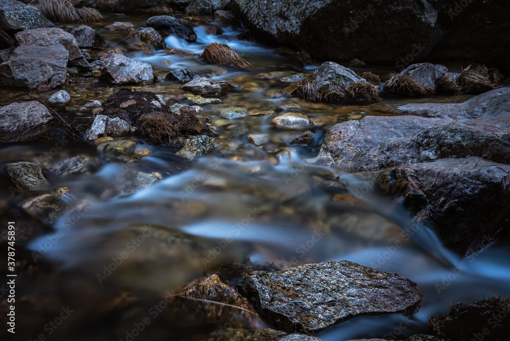 River water flows among the rocks and forms small waterfalls, Rascafría, Madrid, Spain River water flows among the rocks and forms small waterfalls, Rascafría, Madrid, Spain