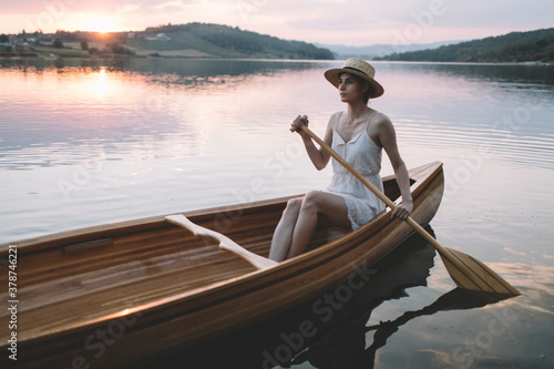 Young woman paddling canoe	