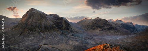 panoramic view of sunrise with tourist on mound in Glencoe, Highlands, Scotland.