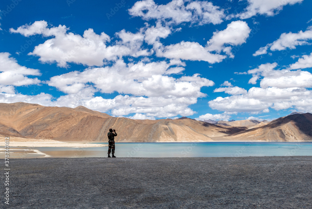 Armyman at Pangong Lake, Ladakh, India. Pangong TSo is an endorheic lake in the Himalayas situated at an elevation of 4,225 m