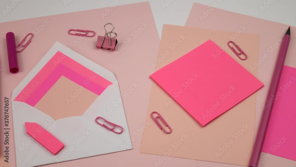 Various stationery in pink are laid out on a white table Various stationery in pink are laid out on a white table