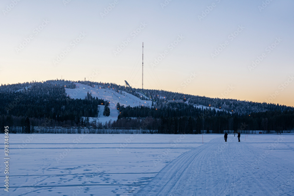 View of Vuokatinvaara hill and ski resort in winter evening, Vuokatti, Kainuu, Finland