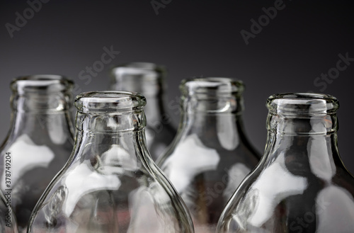 Glass bottles in a row on black background