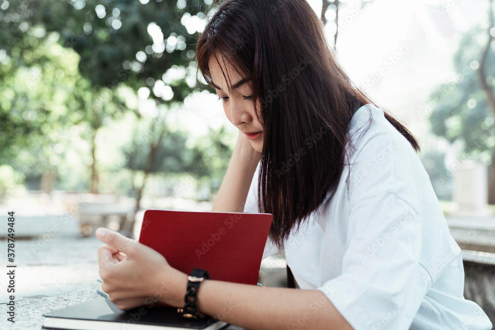 Fototapeta premium University student reading a book at park.