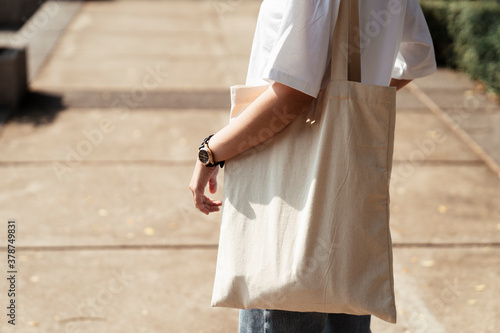 University student holding a cloth bag.