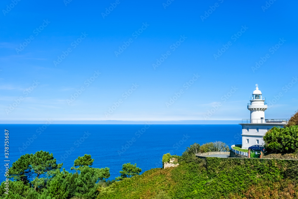 white lighthouse on the shore against the blue sea. Donostia San Sebastian, Basque Country, Spain. Copy space white lighthouse on the shore against the blue sea. Donostia San Sebastian, Basque Country, Spain. Copy space