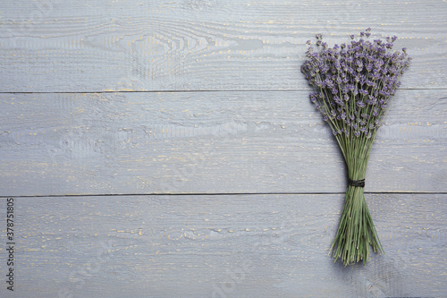 Dried lavender flowers on grey wooden table  top view. Space for text